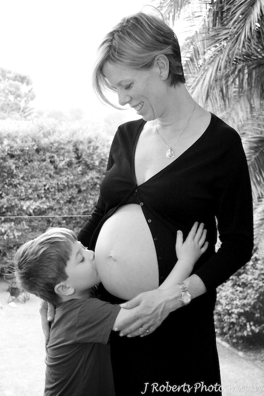 Big brother kissing pregnant belly - B&W pregnancy photography sydney
